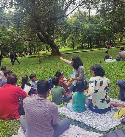 A wider perspective of our story circle, showing how we fit into the larger, vibrant atmosphere of Cubbon Park on a Saturday.