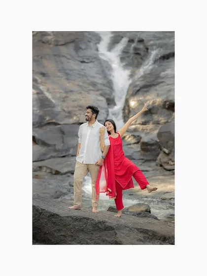A fun and quirky pose by the waterfall. This shot perfectly captures the couple's playful personality and the joy of their pre-wedding adventure.