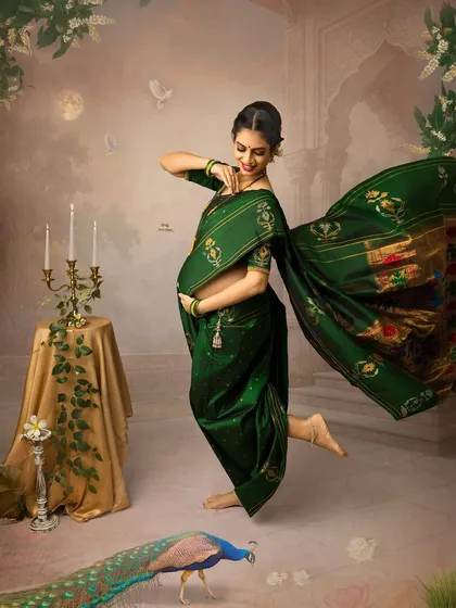 A joyful and dynamic portrait of a mother-to-be in a traditional green saree. This image, part of our fine art series, captures a moment of dance and celebration, reflecting the happiness of this special time.