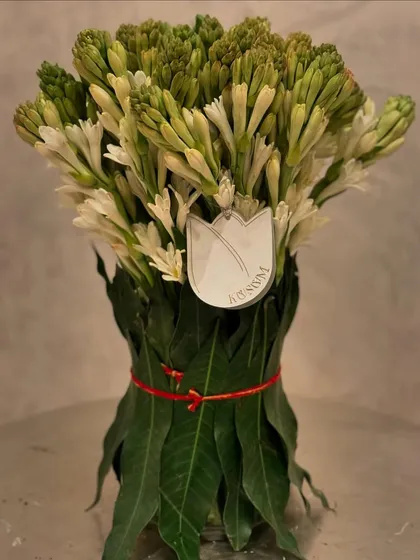 Invite luxury into your home this Diwali. A simple yet elegant bouquet of tuberose, with its stems wrapped in fresh mango leaves, brings a beautiful fragrance and a touch of tradition to your celebration.