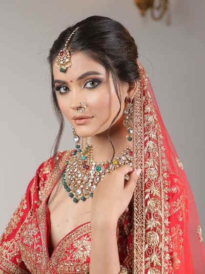 A classic bridal portrait. This look features sharp, defined eyes and a perfectly draped dupatta, capturing the grace and elegance of a traditional Indian bride.