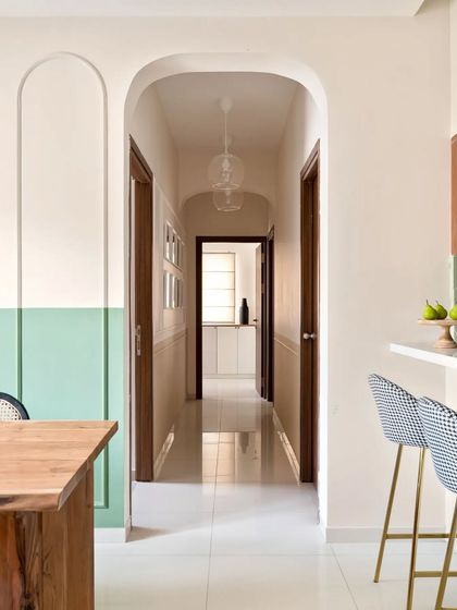 The arched beadings on the dining wall extend to a beautiful arched entryway, creating a seamless flow from the dining area into the passageway.