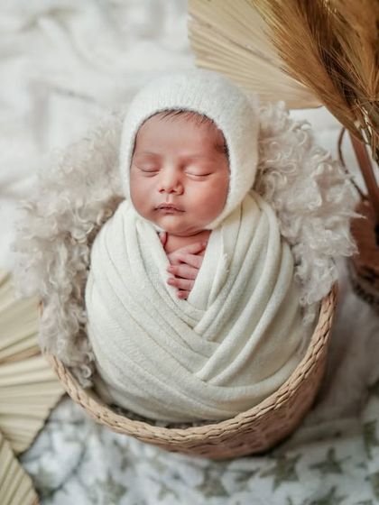 A bundle of love in a boho basket. The neutral colors and natural textures in this setup create a warm and organic feel.