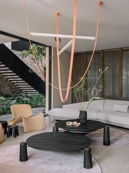 The living room at GAIA, where we combined minimalist furniture with a bold, sculptural light fixture. The room overlooks the central courtyard, reinforcing the home's theme of living with nature.