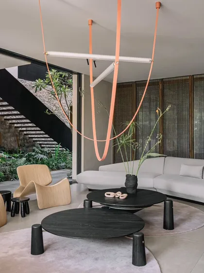 The living room at GAIA, where we combined minimalist furniture with a bold, sculptural light fixture. The room overlooks the central courtyard, reinforcing the home's theme of living with nature.