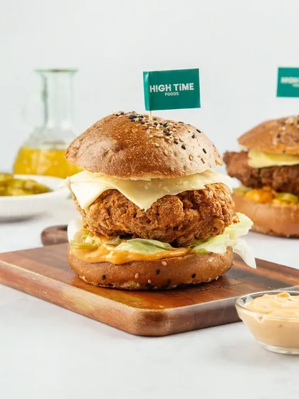 This hero shot of a plant-based crispy chicken burger makes it look incredibly appealing. The clean, bright styling and the branded flag position it as a premium, high-quality product that rivals any traditional burger.