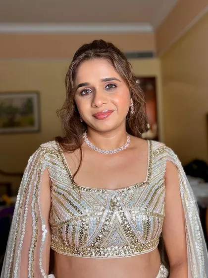 This client is ready for her Sangeet with a half-up hairstyle and sparkling eyes. The glittery eyeshadow is perfect for catching the light on the dance floor.