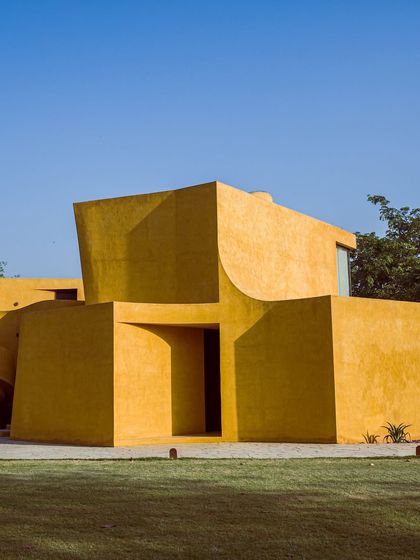 The stark geometry of the building under the bright Delhi sun, creating deep, dramatic shadows.