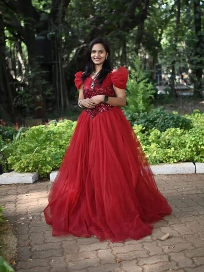 A full-length view of this beautiful red ball gown with puffy sleeves, perfect for a garden pre-wedding shoot.