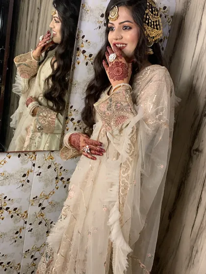 This bride's look is all about classic elegance. The combination of the hairstyle, makeup, and traditional jewellery creates a truly memorable bridal style.