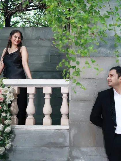A classic pre-wedding pose on a balcony with floral arrangements, capturing a timeless, romantic look.