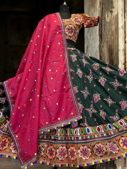 A deep green lehenga with colorful embroidery and a bright pink mirror-work dupatta. This is a rich and elegant option for any Navratri celebration.