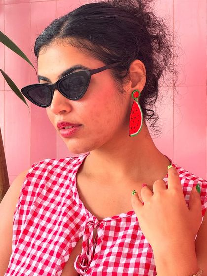 A close-up on the watermelon earrings and cat-eye sunglasses. Accessories are the best way to add personality to any outfit.