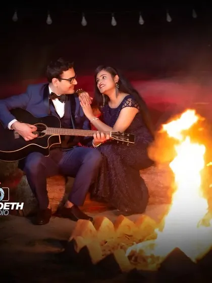 A classic campfire scene, perfect for a musical couple. The fire provides a beautiful, natural light source for a warm and intimate pre-wedding portrait.