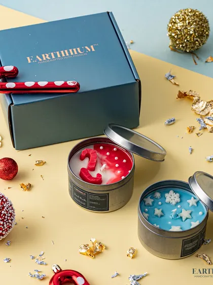 A winter wonderland tin candle set with snowflakes and candy cane designs.