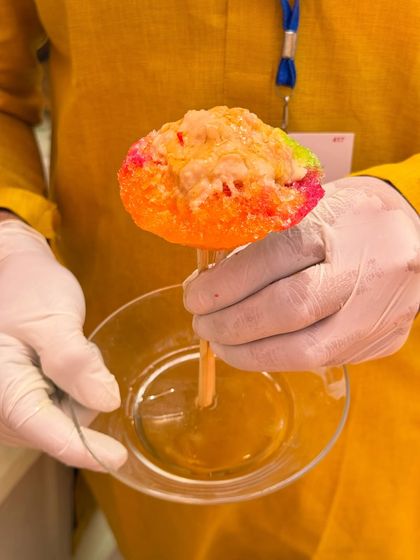 A colourful ice gola, or shaved ice candy, being prepared. This nostalgic treat is a fun and refreshing addition to a daytime event, especially for a Haldi or Mehendi.