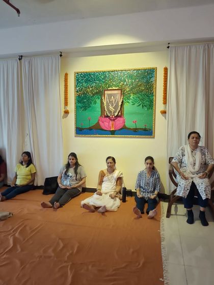 Participants sit for a meditation session at our studio. You can see the diverse group of people who come together, including those who use a chair for support, showing that yoga is accessible to everyone.