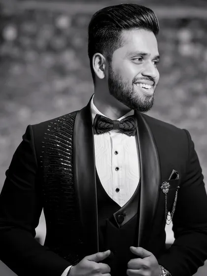 A classic black and white portrait of the groom. His confident smile and sharp tuxedo are captured in this timeless, dapper shot.