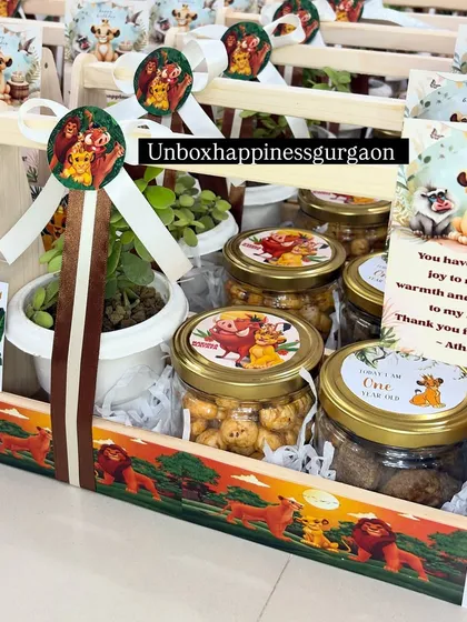 A complete 'Lion King' return gift basket, featuring a plant, jars of treats, and fully customized themed decorations.