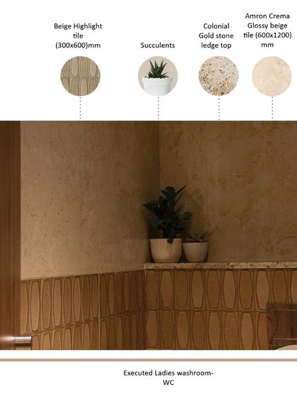 The executed ladies' WC combines different tile textures for a subtle, layered effect. A beige highlight tile creates a wainscoting effect, while succulents and warm, indirect lighting contribute to a tranquil and refreshing atmosphere.