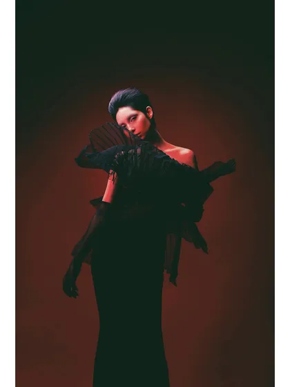 A more pensive pose from the 'Athena' series. The styling of the black sculptural piece is the focus, with the model's pose adding a touch of vulnerability to the powerful look.