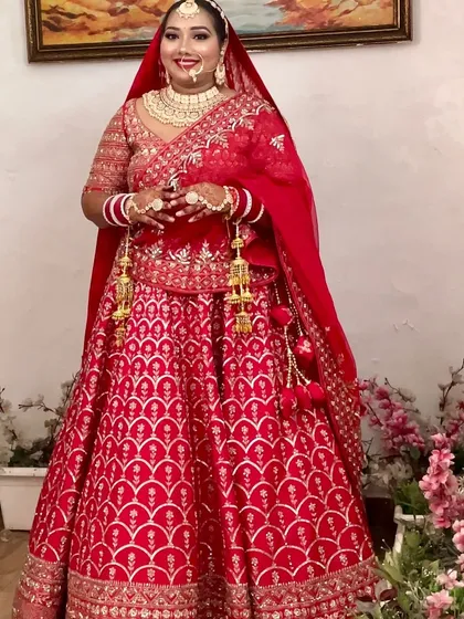 A stunning bride in a classic red lehenga. This unfiltered, unedited shot shows the true quality of the HD makeup, designed to look flawless in any light.