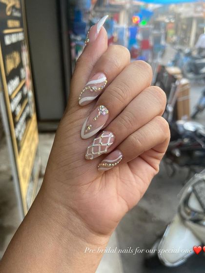 Pre-bridal nail extensions featuring a nude base with an elegant white lattice design and rhinestone details.
