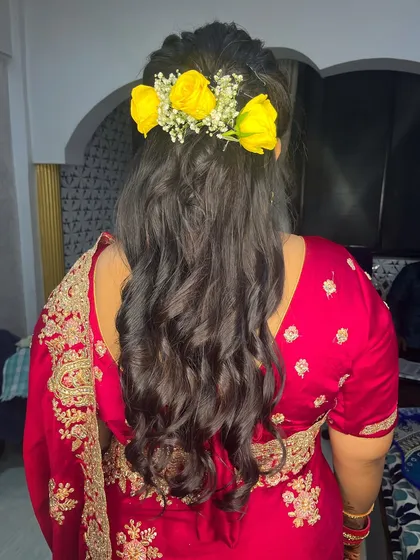 Pretty curls adorned with fresh yellow roses and baby's breath. This is a vibrant and cheerful hairstyle for any celebration.