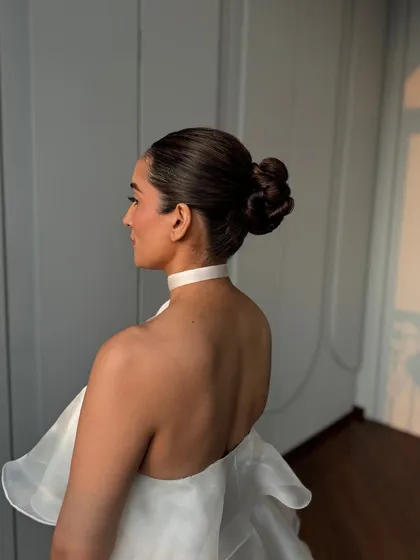 A side profile of the sleek, modern bun. This hairstyle is all about clean lines and sophistication, perfect for a minimalist bride or a high-fashion event.