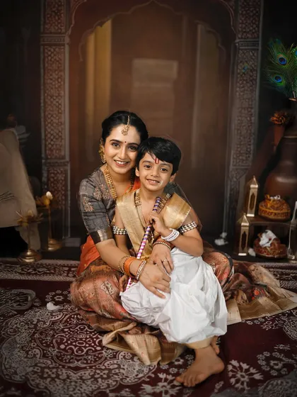 A smiling portrait of a mother and son in their beautiful traditional attire for the Krishna-themed shoot.