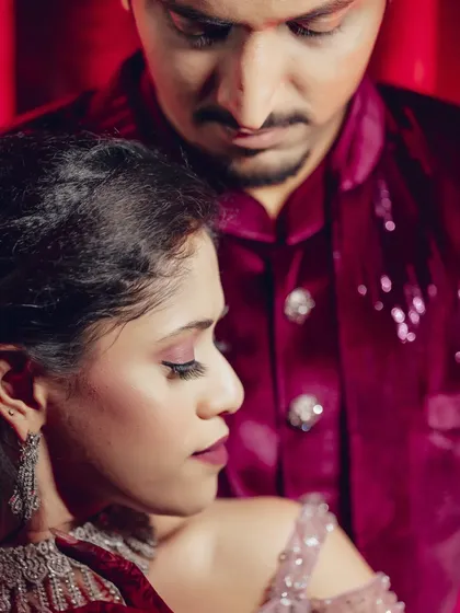 A close-up, artistic shot focusing on expression and mood. The deep red lighting and intimate framing create a powerful and emotional portrait.
