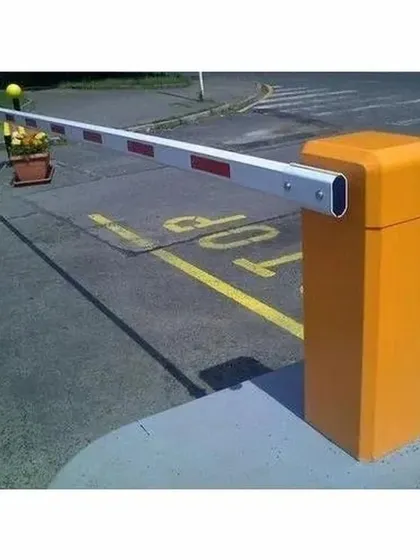 A heavy-duty boom barrier installed to manage vehicular traffic at an entry point. These systems are essential for controlling access in parking lots, corporate campuses, and residential communities, and can be integrated with FASTAG or RFID readers.