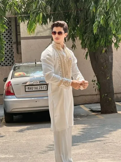 An all-white kurta set with gold embroidery, a timeless choice for festive occasions.