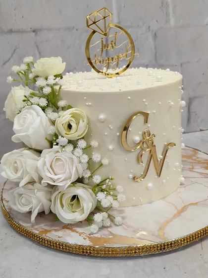 From this angle, you can see the beautiful texture and the elegant "Just Engaged" topper that completes this sophisticated celebration cake.