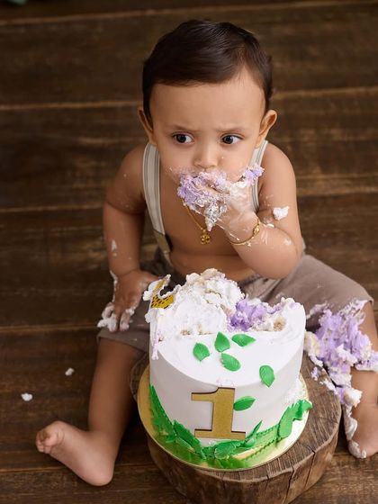 A candid moment of a baby boy thoroughly enjoying his first birthday cake. We focus on capturing the real, unposed joy of the experience.