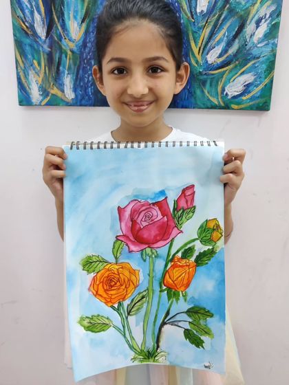 A young artist holds up her beautiful watercolor painting of roses, demonstrating her skill in color blending and creating delicate floral forms.