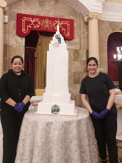 My amazing team members standing proudly next to the Empire State Building cake after assembling it on-site.