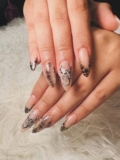 A full view of the edgy and unique scorpion nail art set.