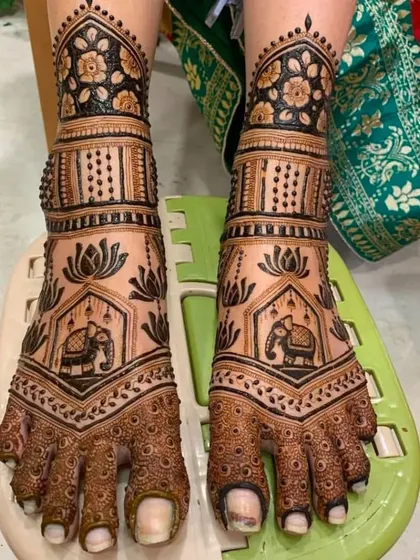An elegant foot mehendi design with elephant motifs and lotus flowers.
