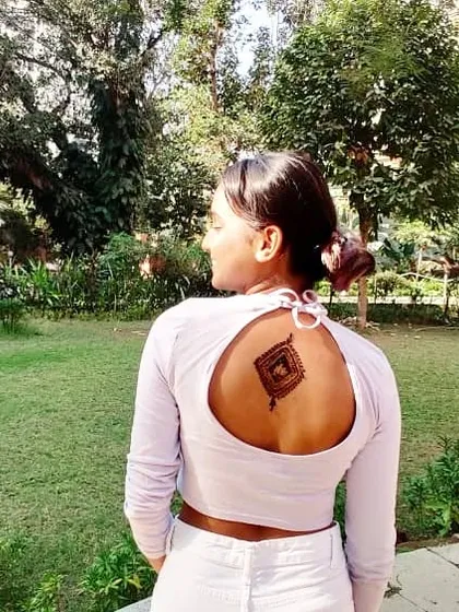 A modern take on geometric design, with a diamond-shaped mandala placed as a temporary tattoo on the back.