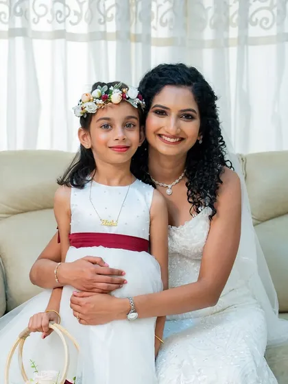 A sweet moment with the flower girl. The bride's makeup is soft and natural, making her look approachable and radiant.