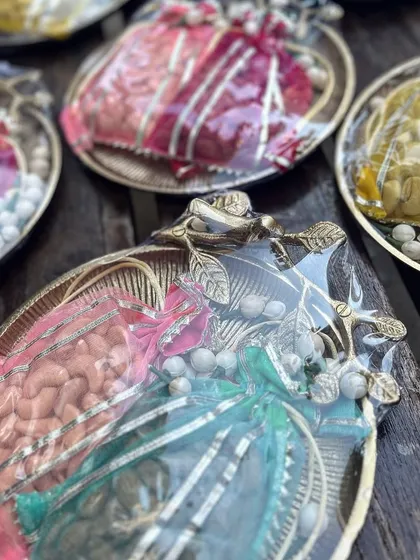 A closer look at the "Jashn" festive platters, showing the variety of colorful potlis. Each one is carefully wrapped and arranged to create a symphony of color and texture.