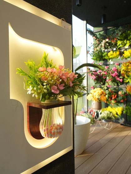 We also offer small decorative elements like this backlit wall niche with an artificial flower arrangement, perfect for adding a touch of elegance.