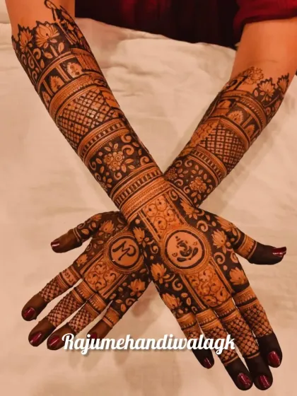 This design incorporates Lord Ganesha on the palm for blessings and auspicious beginnings. The rest of the arm is filled with floral patterns and the couple's initials.