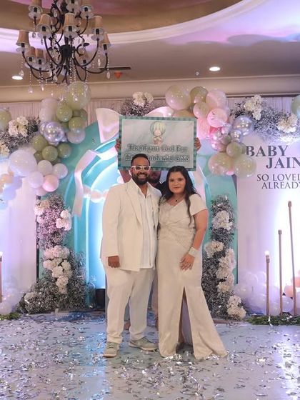 The parents-to-be standing in a shower of confetti. This photo captures a moment of pure, unadulterated joy and celebration.