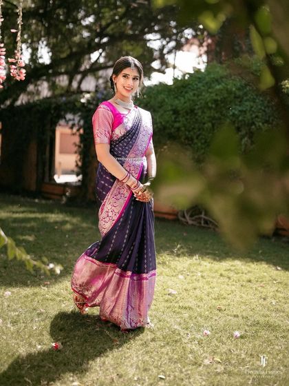 A full-length shot of the bride in a garden, her vibrant saree standing out against the green background.