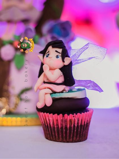 A pensive-looking fairy topper, adding a bit of sweet emotion to the cupcake collection.