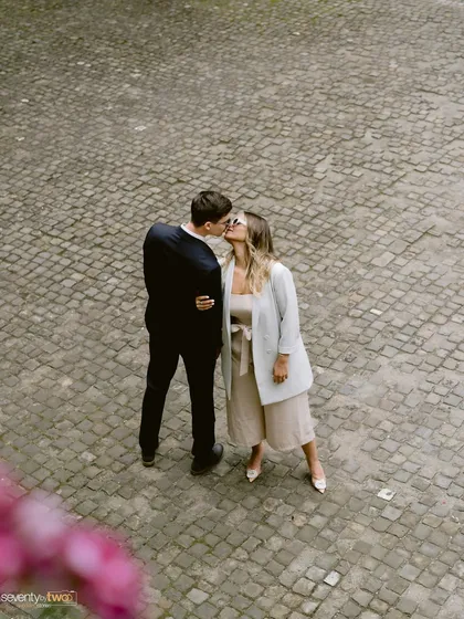 A stolen kiss in a cobblestone courtyard, seen from above. This unique perspective adds a touch of romance and artistry to their story.
