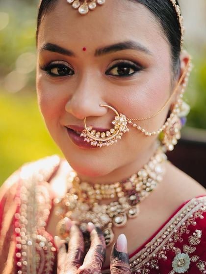A close-up of Kritika's bridal makeup. The focus is on her beautiful nath and the perfectly blended eye makeup that makes her eyes pop.