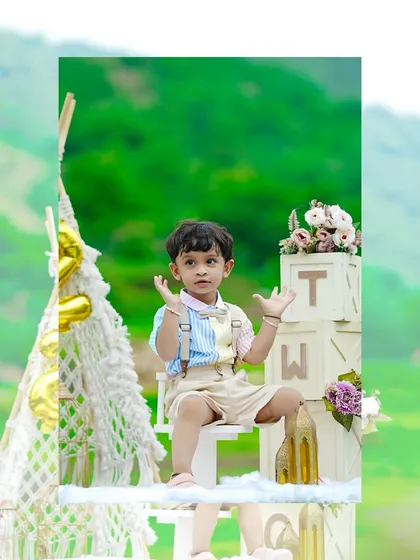 A creative shot of a two-year-old boy sitting on 'TWO' blocks, framed to look like a polaroid picture, adding a fun touch to his birthday shoot.
